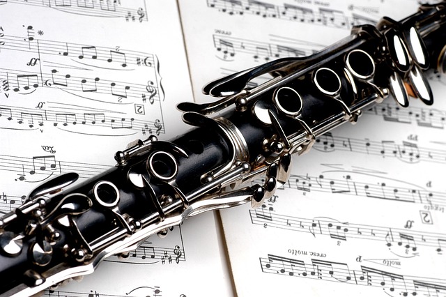 Close-up of a clarinet's keys and mouthpiece resting on sheet music
