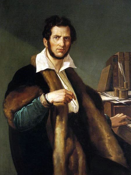 Painted portrait of Gaetano Donizetti with dark curly hair, wrapped in a fur-lined cloak, seated beside a desk with books