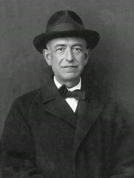 Black-and-white photograph of Manuel de Falla, a slight man with a lined face, in a dark hat, coat, and bow tie