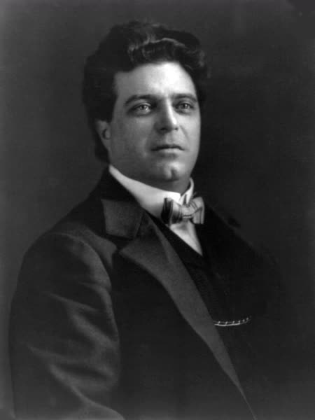 Black-and-white photograph of Pietro Mascagni with thick dark hair, wearing a dark suit and bow tie