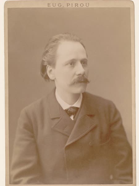 Sepia studio photograph of Jules Massenet with swept-back hair and a moustache, wearing a dark coat