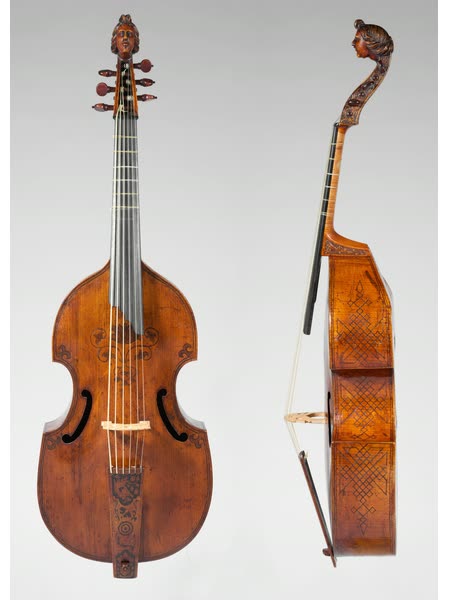 A viola da gamba shown from the front and side: a bowed instrument with sloping shoulders, C-shaped soundholes, a flat back, and a carved head